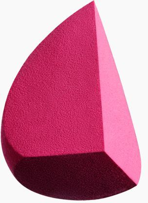 Een roze driehoekige make-up spons met een getextureerd oppervlak en afgeronde randen.