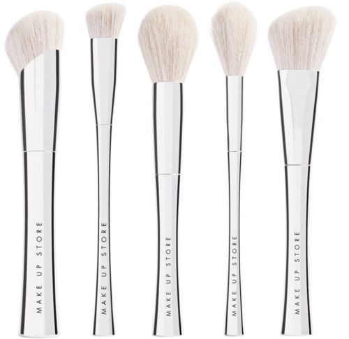 Five makeup brushes with white bristles and silver handles are lined up. Each handle has 