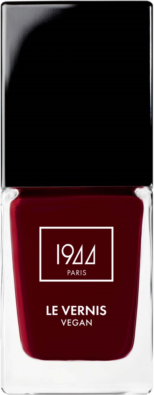 Vegan nagellakfles met zwarte deksel, witte tekst en rood vloeistof binnenin. Het etiket zegt "1944 PARIS LE VERNIS VEGAN."