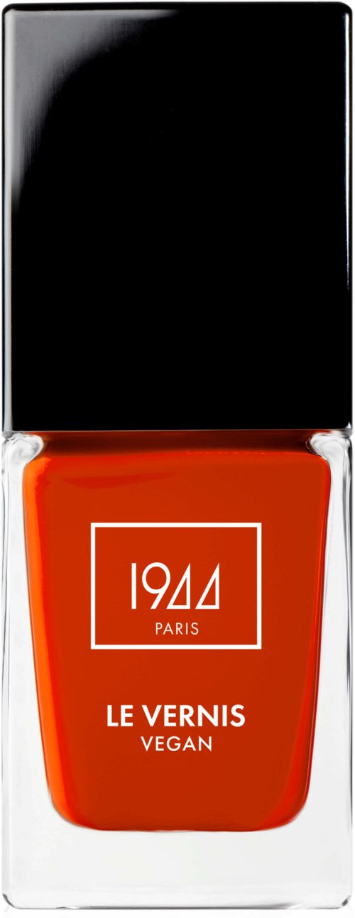 Een fles vegan nagellak met zwarte dop, rode lak en witte tekst op het label.