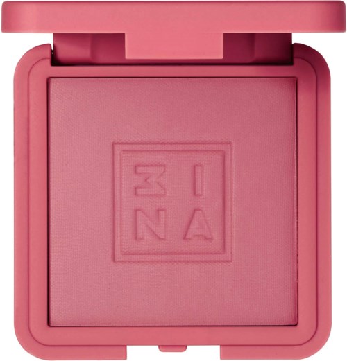 A pink makeup blush compact with a closed lid, featuring a central embossed logo. The blush inside is also pink.