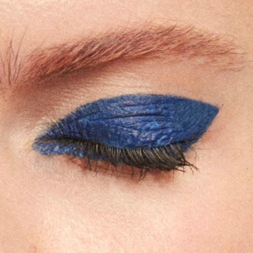 Smokey eye makeup with blue eyeshadow and prominent eyelashes.