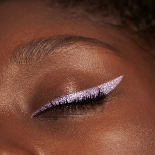 Ett öga med smink, inklusive lila ögonskugga och en slående vit eyeliner med vinge.