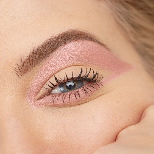 Close-up of a person's eye with makeup, showing long eyelashes, blue eye color, and soft skin.
