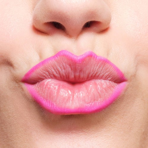 Close-up of lips with pink lipstick, slightly parted, showing smooth skin and natural lip texture.