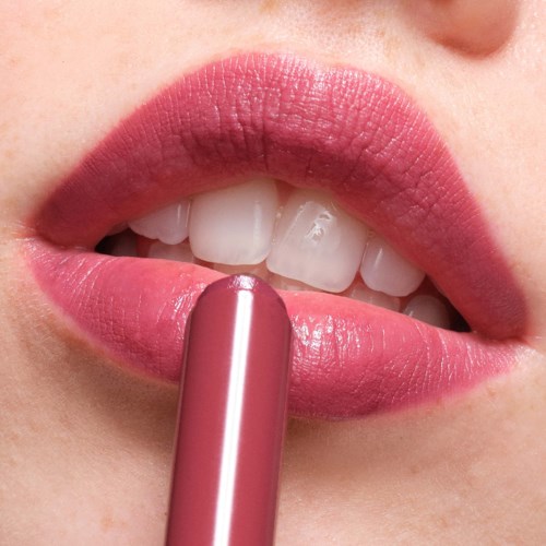 Person som påfører rosa leppestift på leppene, viser tenner og lepper tett på.