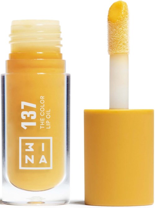 A yellow lip oil container with a white applicator stick inside, partially coated with yellow gloss.