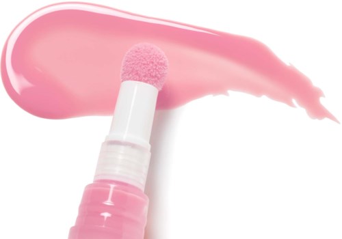 En rosa applikator med rosa kräm eller lotion utbredd på vit bakgrund.