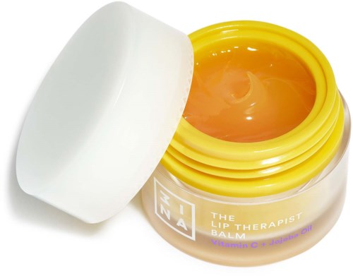 A yellow jar with a white lid, filled with a balm containing vitamin C and jojoba oil.