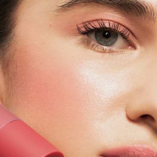Close-up of a woman's eye with makeup and smooth skin, showing detailed eyelashes and eye color.