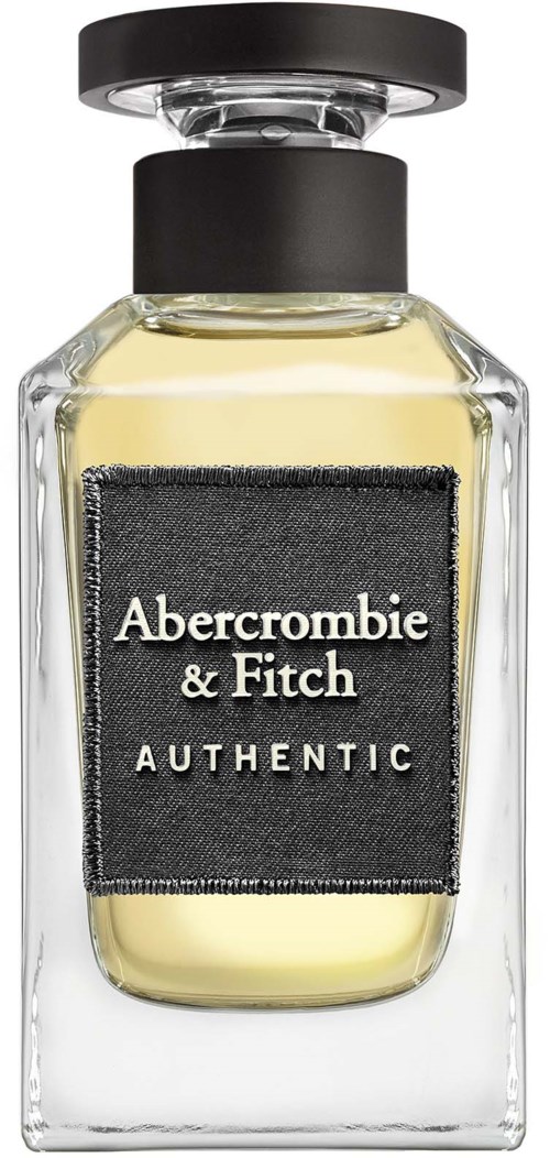 Een heldere glazen parfumfles met een zwarte dop en een zwart etiket met witte tekst. De parfum is lichtgeel.