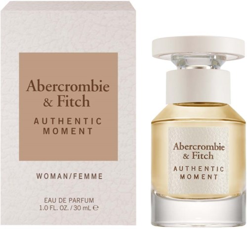 Een parfumfles en doos met beige en witte kleuren, gemarkeerd 'Abercrombie & Fitch Authentic Moment'.