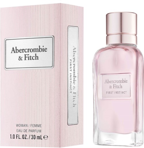 Een roze parfumfles en doos met Abercrombie & Fitch First Instinct label, stijlvol en vrouwelijk. Ze staan naast elkaar.