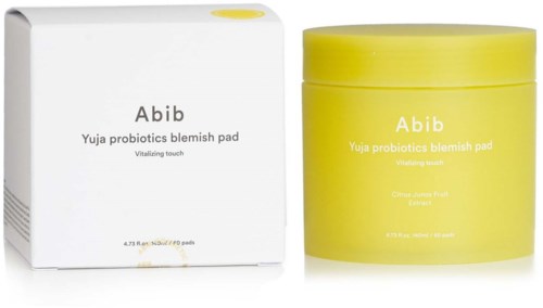 Een witte doos en een gele pot met huidverzorgingsproducten labeled 'Abib Yuja probiotics blemish pad' en 'Vitalizing touch.'