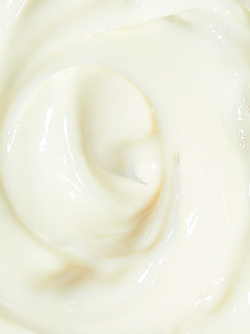 Een gladde spiraal van witte room of yoghurt met een glanzende textuur.