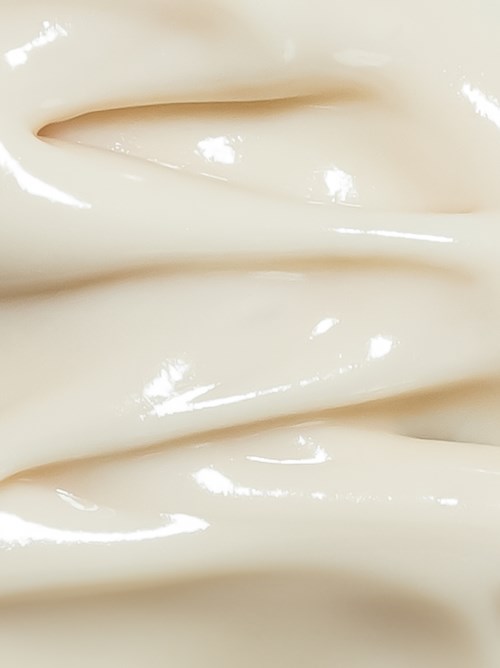Een close-up van een glad, glanzend witte oppervlak met zachte vouwen of plooien.