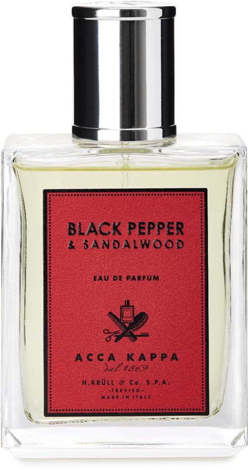 En tydlig parfyllflaska med en röd etikett som står 'Black Pepper & Sandalwood' och har ett silverlock.