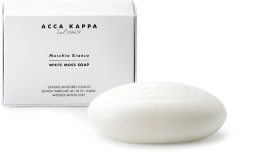 Eine weiße Seife vor einer weißen Schachtel mit schwarzem Text, beschriftet Muschio Bianco White Moss Soap.