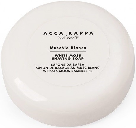 A round white soap container with a label that has text in multiple languages about a shaving soap.