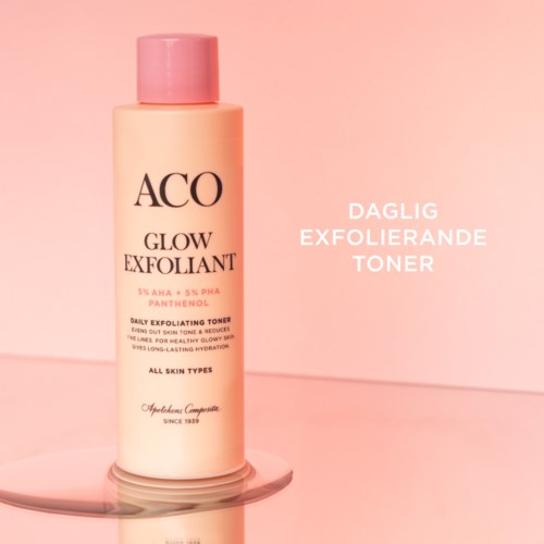 Eine Hautpflegeflasche mit der Beschriftung ACO Glow Exfoliant und Anweisungen auf Norwegisch, vor pinkem Hintergrund.