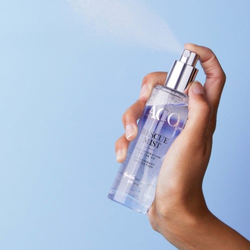 En hand sprayar klar vätska från en flaska märkt 'Rescue Mist' mot en blå bakgrund.