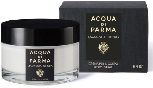 A white body cream in a round jar next to a black box, both labeled 'Acqua di Parma Magnolia Infinita.'