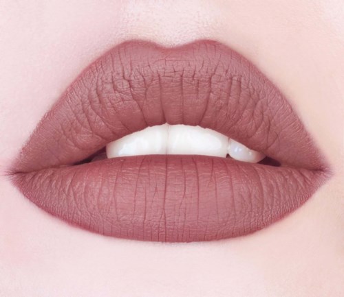 Närbild av läppar med neutral makeup, lätt Open, visar tänder.
