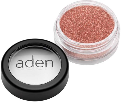 Ein kleiner Behälter mit rosafarbenem Glitter und schwarzem Deckel mit der Aufschrift "aden".