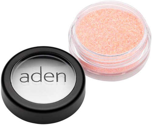 A small round container with pink shimmering powder and a black lid with the word 'aden'.