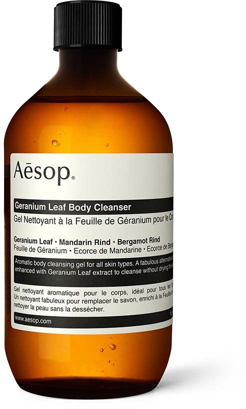 En brun flaska med Aesop Geranium Leaf Body Cleanser med svart lock och vitt märke.
