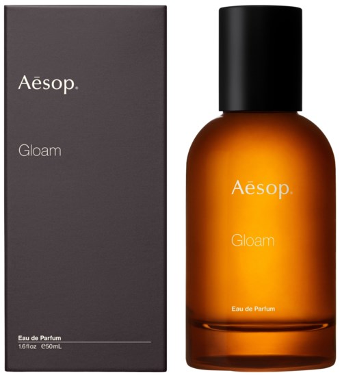 Eine braune Parfüflasche und eine graue Schachtel, beide mit den Labels 'Aesop Twee.' und 'Gloam', mit schwarzen Deckeln.