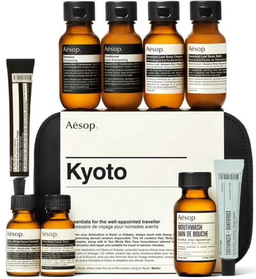 Aesop matkakokoisten ihon- ja hiustenhoitotuotteiden setti, johon liittyy Kyoto-aiheinen ilmoitus, sisältäen shampoota, hoitoaineita, puhdistusaineita ja balsamia.