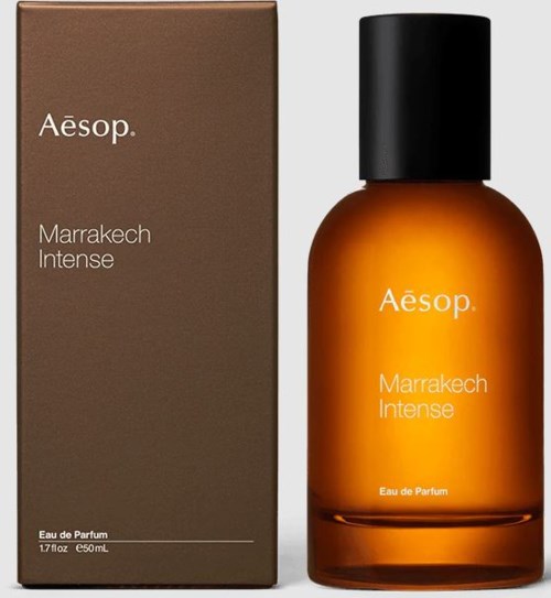 Eine Flasche mit schwarzem Deckel neben einem braunen Karton. Der Karton und die Flasche tragen beide die Aufschrift 'Aesop Marrakech Intense'.