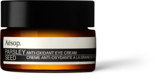 Ein kleiner Behälter mit Aesop Petersilien-Augencreme mit schwarzem Deckel und einfacher Etikette.