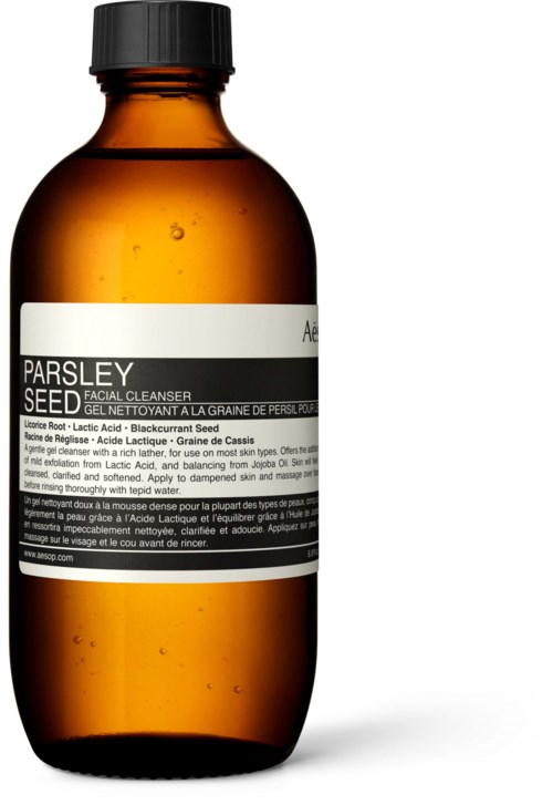 Eine braune Flasche mit schwarzem Verschluss, gekennzeichnet mit 'Parsley Seed Facial Cleanser' in weißem und schwarzem Text.