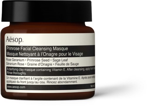 Ein kleiner brauner Behälter mit schwarzem Deckel, gekennzeichnet als Aesop Primrose Facial Cleansing Masque, mit Anweisungen.