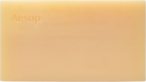 Ein rechteckiger Karton mit sanfter orange Farbe und dem Markennamen Aesop.