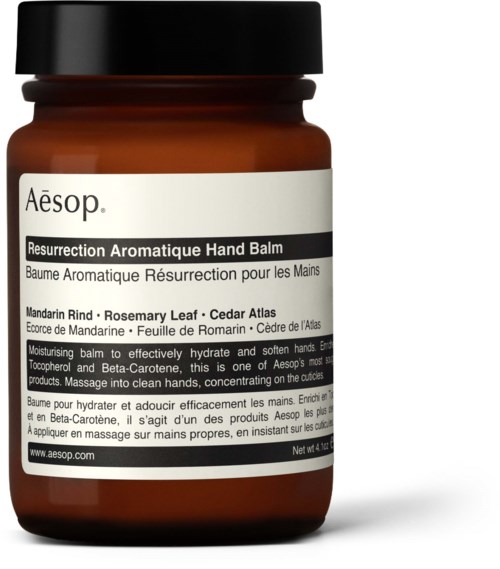 Brunt handkrämglas med vit etikett och svart lock, med produktnamn och ingredienser.