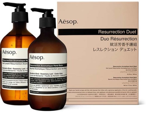 To brune flasker med Aesop hånd- og ansiktsvask foran en beige eske merket 'Resurrection Duet'.