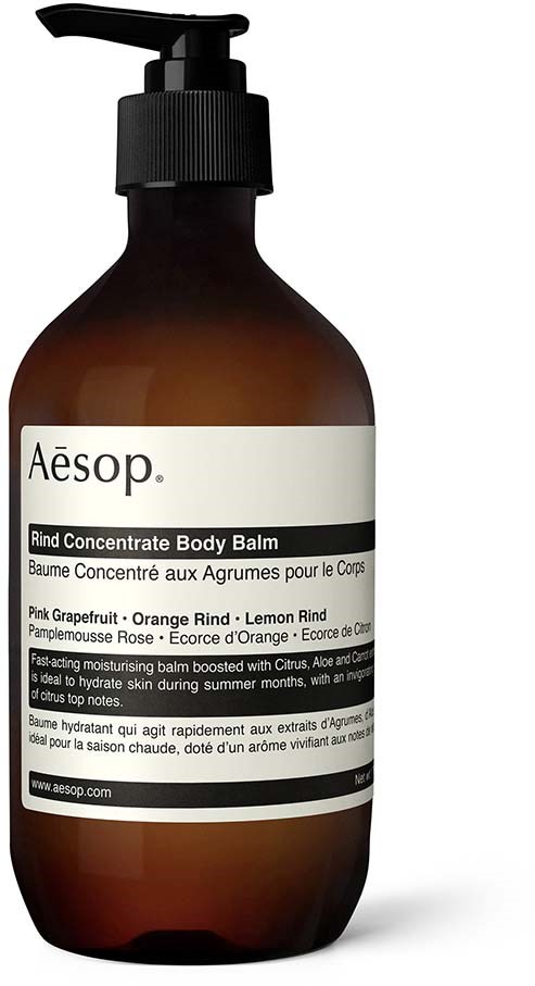 Eine Flasche Aesop Rind Body Balm mit schwarzem Pumpenverschluss und weißem Etikett, das es als Zitrus- und Frucht-Feuchtigkeitscreme beschreibt.