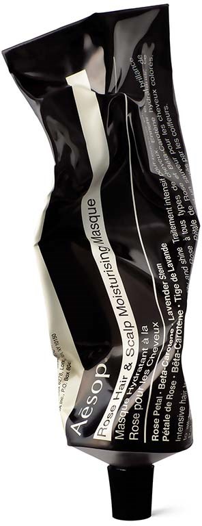 A black tube with white and gray label, crumpled, containing Aesop scalp and hair mask.