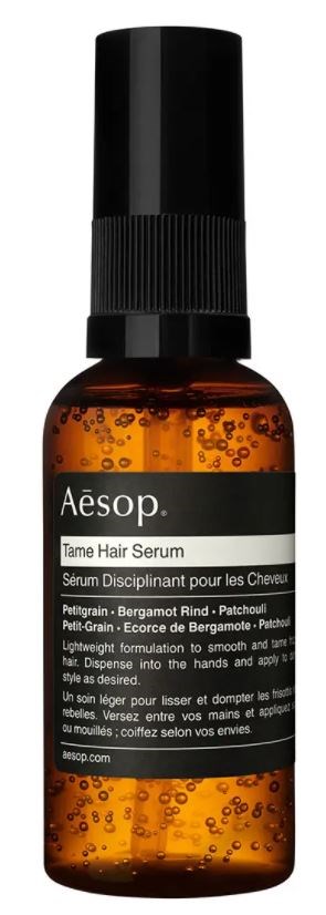 Eine braune Flasche Aesop Tame Hair Serum mit schwarzem Sprühkopf und schwarz-weißem Etikett.