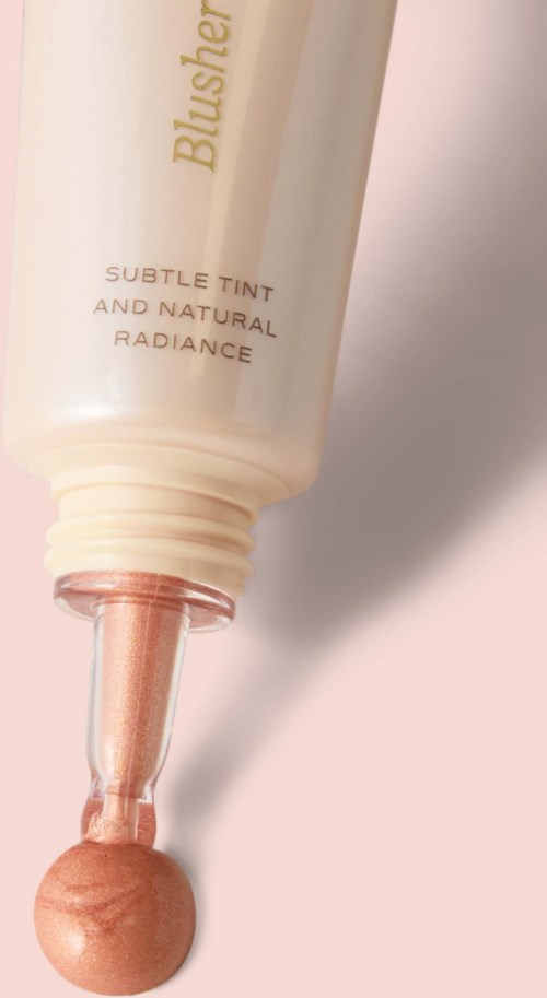 Een tube blush met een kwast en een beige, glanzende vloeistof.