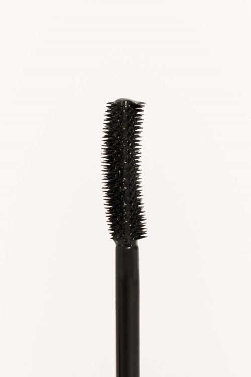 A black mascara brush with a curved, spiky design on a plain white background.
