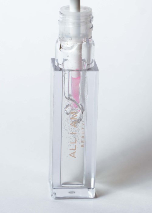 A clear, rectangular glass bottle with a white dropper cap, partially filled with a transparent liquid, labeled All Day Beauty.