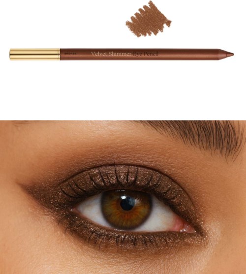 Ein braunes Auge mit goldener Schimmer-Augenhadow, Eyeliner und Mascara. Ein brauner Augenstift mit der Aufschrift 'Velvet Shimmer Eye Pencil' ist darüber.
