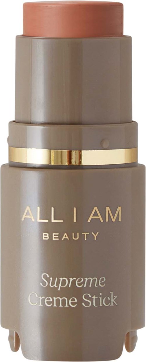 A beige bottle with a pinkish top and gold band, labeled 'ALL I AM BEAUTY Supreme Creme Stick'.