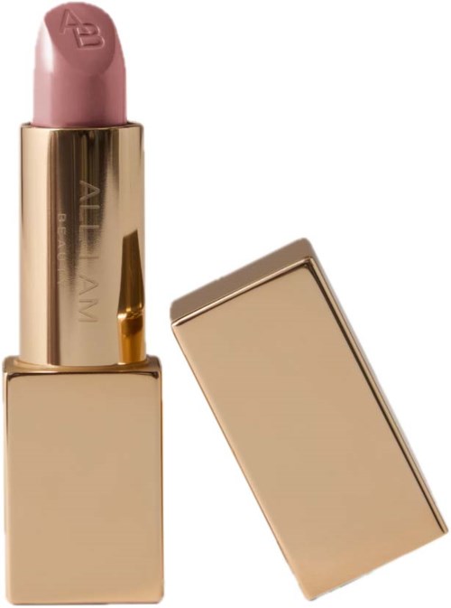 A pink lipstick in a shiny gold tube with the cap off, next to its matching gold cap.