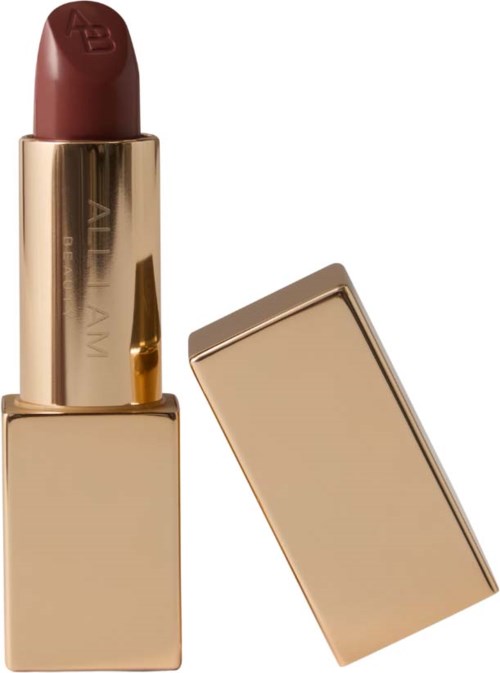 A lipstick with a brown shade in a gold case, with its cap removed and beside it.