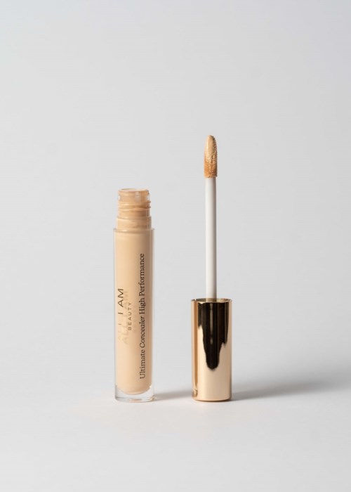 Een beige lipgloss tube met applicator staand rechtop op een eenvoudige achtergrond.